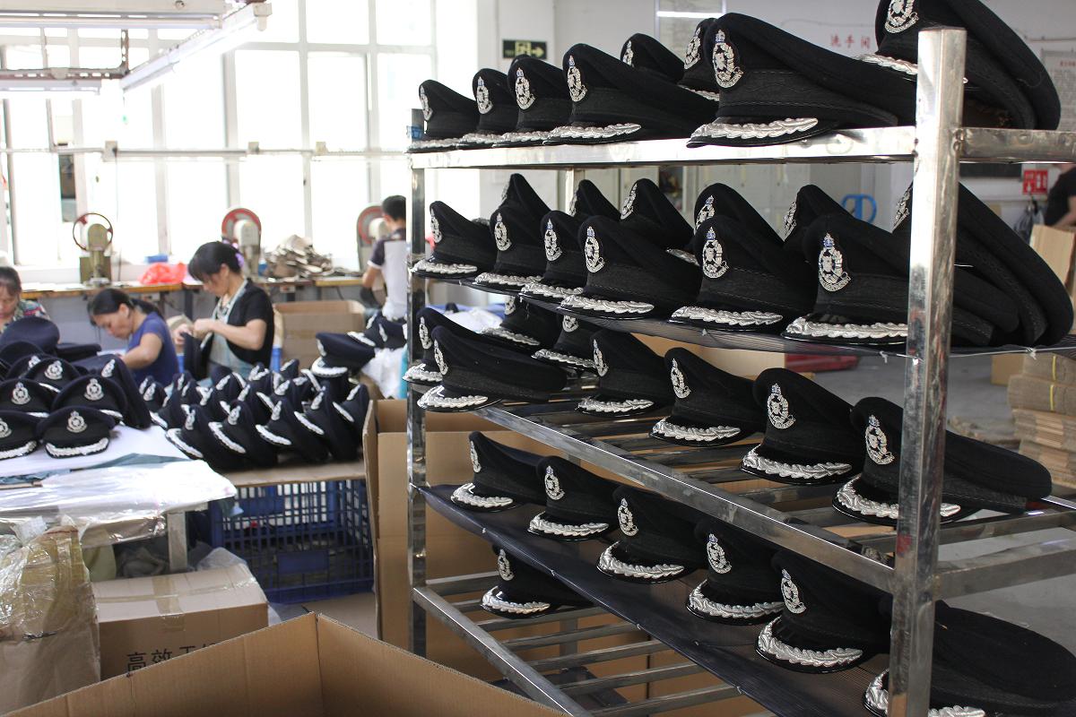 Custom police peaked caps with badges in the StarCap factory